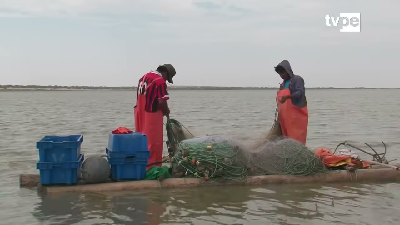 Pescadores en balsa en la laguna La Niña