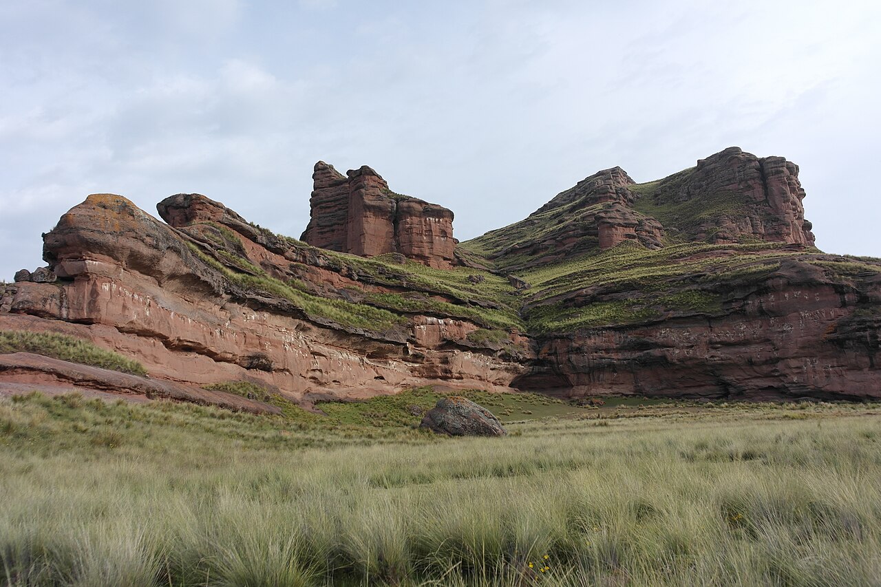 Peñas rojizas sobre el pajonal de Tinajani